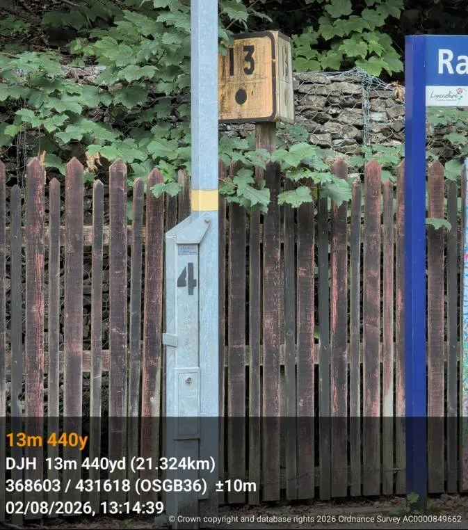A photo of a milepost, stamped with the ELR, mileage, grid reference and time.